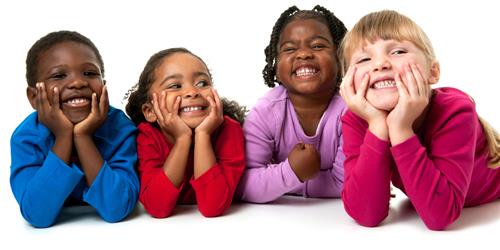 one little boy and three little girls smiling while lying on their tummies one little boy and three little girls smiling while lying on their tummies